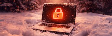 Verschneiter Laptop im Wald mit leuchtendem Schloss-Symbol auf dem Bildschirm