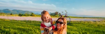 Zwei Personen machen Selfie im grünen Feld bei Sonne, Fahrrad hinten