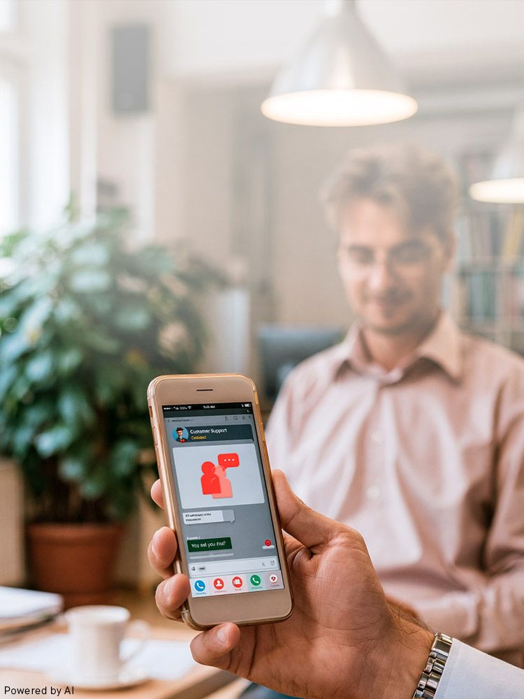 Person hält Smartphone mit geöffneter Kunden-Support-Chat-App, unscharfer Mann im Hintergrund.