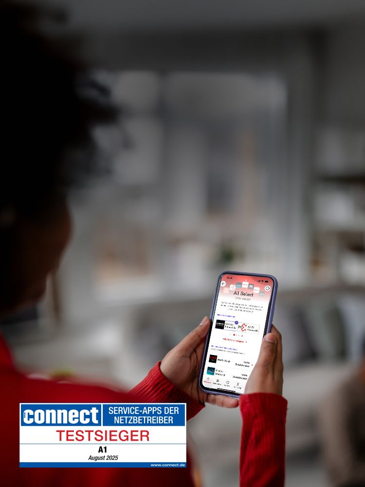 Person hält Smartphone mit geöffneter App. Links Siegel: connect TESTSIEGER SERVICE-APPS DER NETZBETREIBER, A1, August 2025.