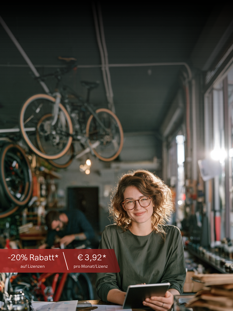 Frau mit Tablet in Fahrradwerkstatt, Text im Vordergrund: "-20% Rabatt* auf Lizenzen, € 3,92* pro Monat/Lizenz".